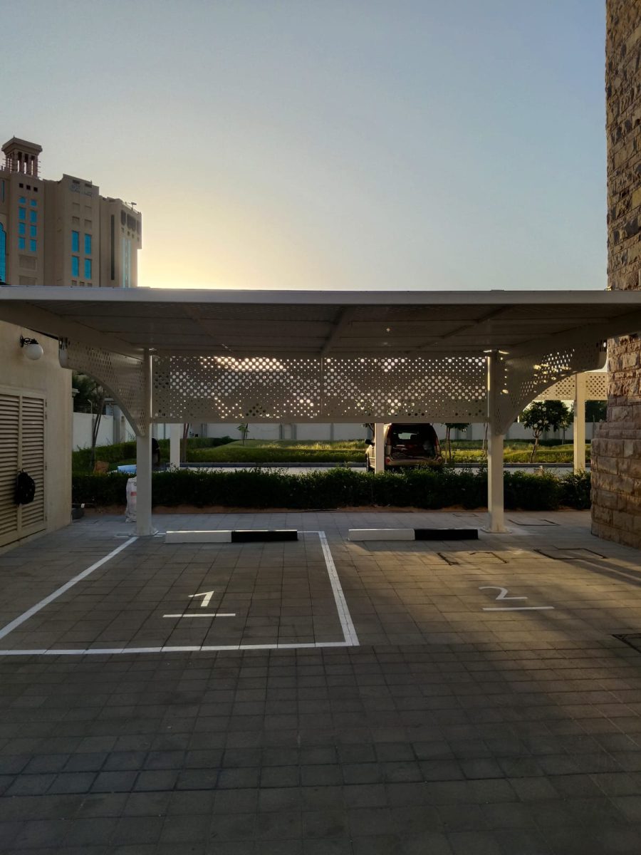 Symmetrical frontal elevation of parking bays with ambient golden hour light filtering through perforated roof