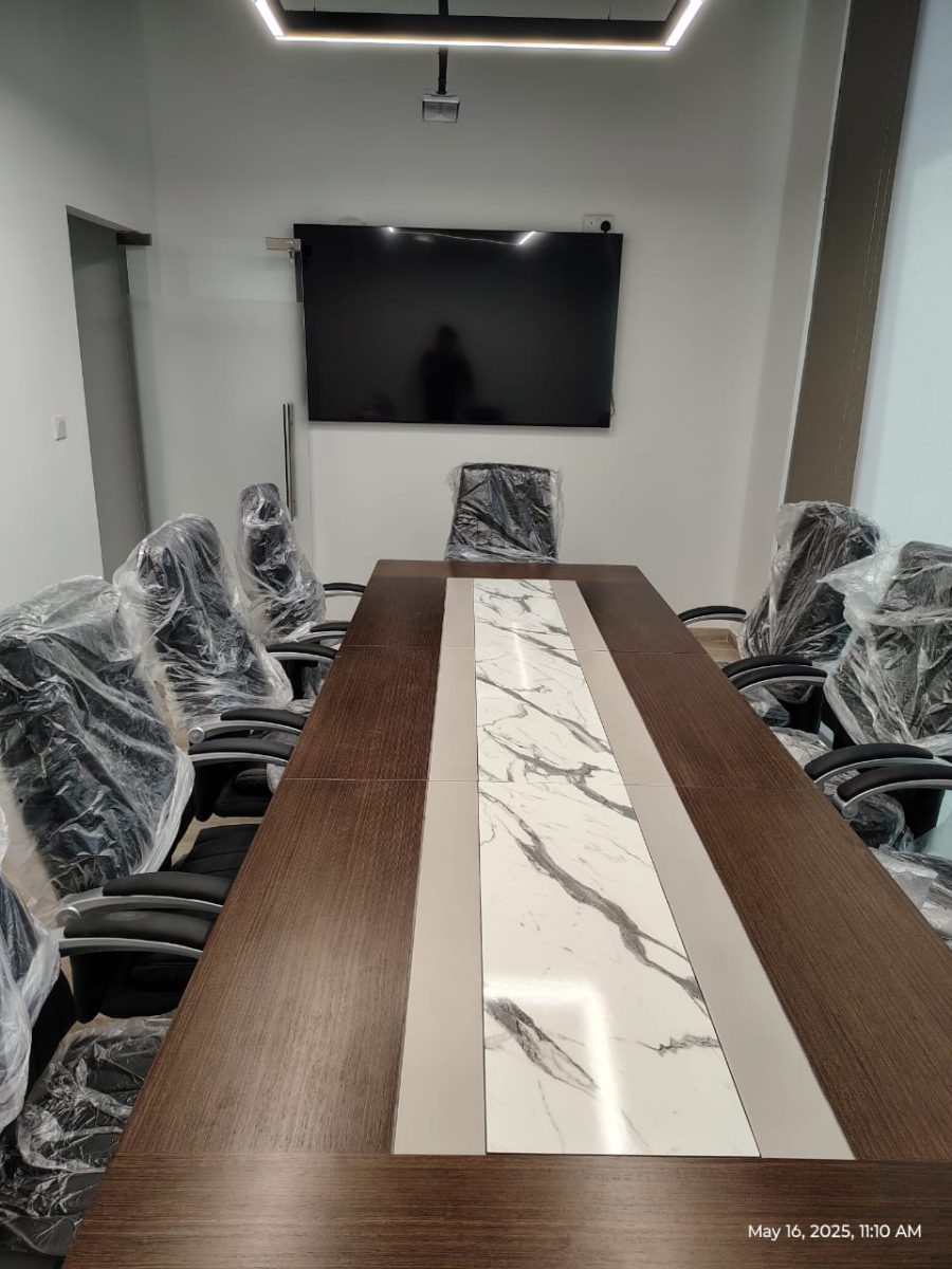 Custom dark walnut boardroom conference table with Calacatta marble runner and integrated AV connectivity at Expo City