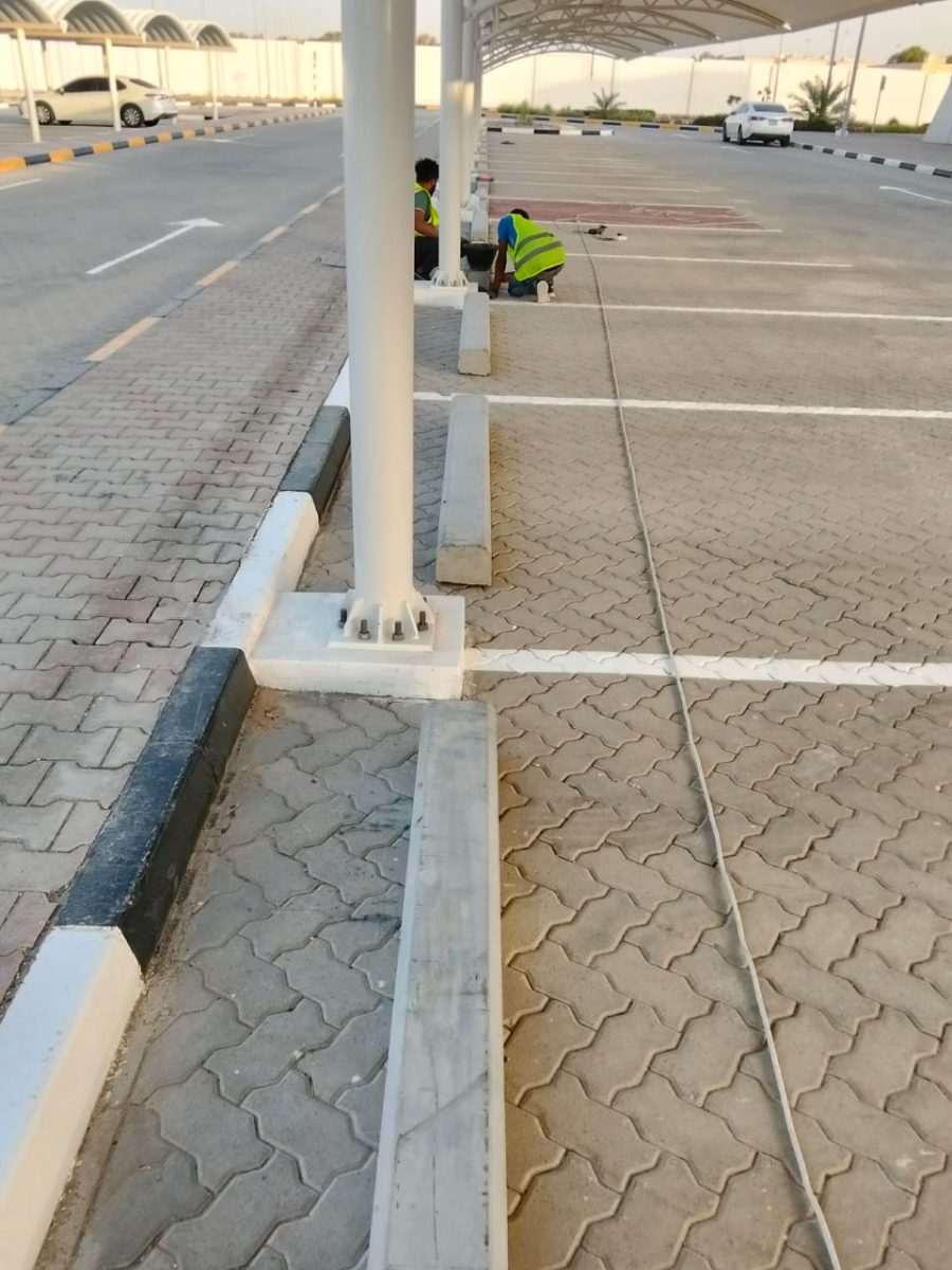 Reinforced concrete pedestals, gusseted base plates with anchor bolts, precast wheel stops and safety kerbstone painting